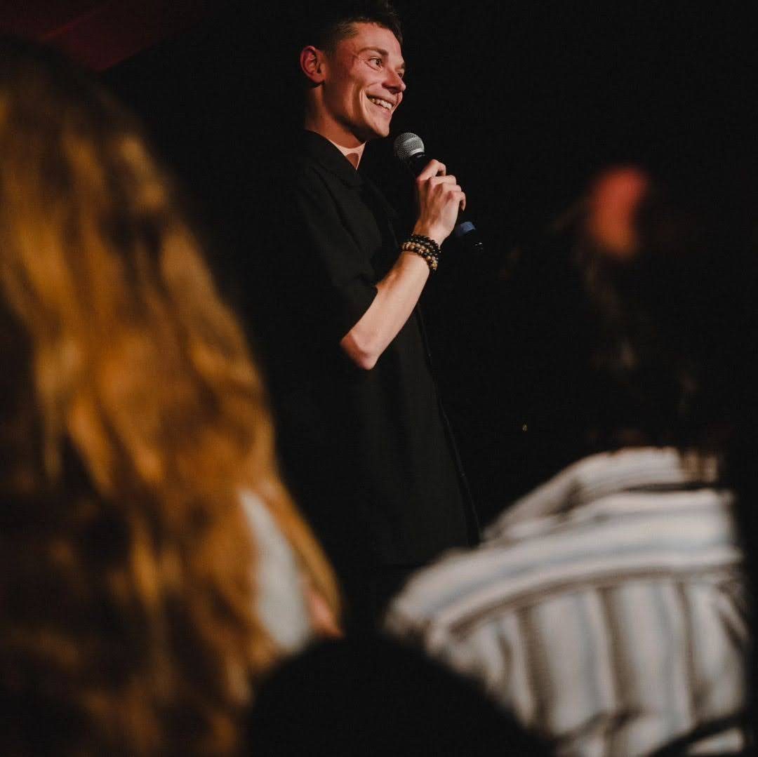 Tom Boudet sur la scène de L'Estrade, micro en main, sourire aux lèvres face au public